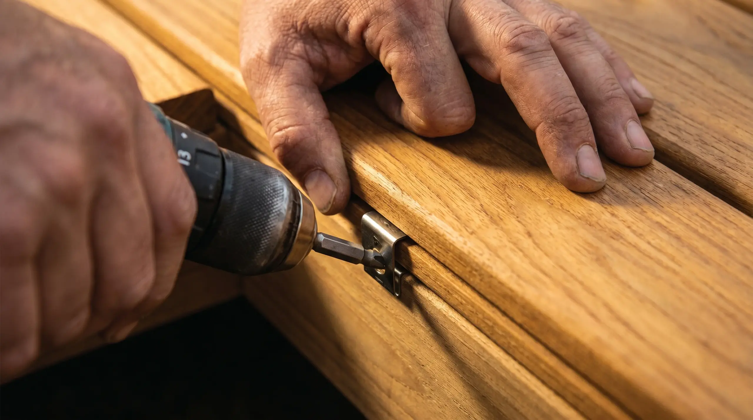 Terrassendielen verlegen – Detail: Edelstahl-Clips und Holzdielen beim Einbauen